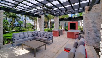 A patio with couches and tables under a pergola